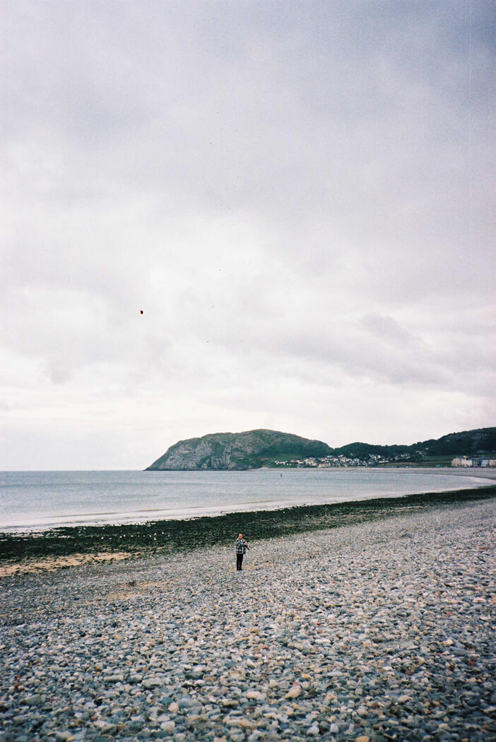 A man standing on a Rocky beach in North Wales