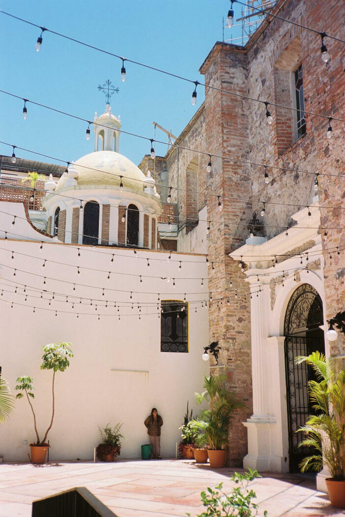 A woman leaning on a wall in a church courtyard